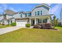 Attractive home featuring a two-car garage, manicured lawn, and welcoming front porch at 1110 Sapling Dr, Summerville, SC 29485