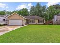 Single-story home with an attached garage and lush green lawn at 112 Red Cypress Dr, Goose Creek, SC 29445