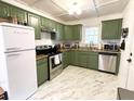 Modern kitchen with stainless steel appliances, olive green cabinets, and marble flooring at 1159 Camden St, North Charleston, SC 29405