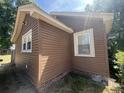 Corner view showcasing brown siding, white trim, and foundation brickwork at 117 Weiters St, Walterboro, SC 29488
