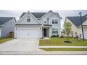 Beautifully designed two-story house with a spacious driveway and lush green lawn adding to its charm at 124 Long Trail Way, Moncks Corner, SC 29461