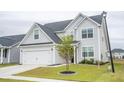 Stylish two-story home with a verdant front yard and newly planted tree enhancing its curb appeal at 124 Long Trail Way, Moncks Corner, SC 29461