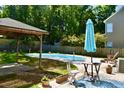 Backyard oasis with a pool, patio, gazebo, and blue umbrella at 132 E Hartwick Ln, Goose Creek, SC 29445