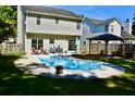 Backyard pool surrounded by a concrete patio, chairs, and manicured grass at 132 E Hartwick Ln, Goose Creek, SC 29445