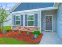 Charming home featuring a welcoming front yard with stone accents and a decorative wreath on the front door at 137 Clydesdale Cir, Summerville, SC 29486