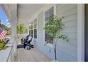 Inviting porch with outdoor seating, white columns, and a glimpse of the surrounding scenery at 1513 Cultivation Ln, Mount Pleasant, SC 29466