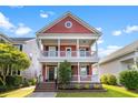 Charming two-story home with double porches, a red facade, a black front door and manicured front lawn at 218 Barberry St, Summerville, SC 29483