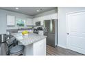 Modern kitchen featuring granite countertops, stainless steel appliances, a kitchen island with seating, and white cabinetry at 222 Torslanda Ln, Summerville, SC 29486