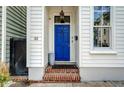 Inviting entryway featuring a vibrant blue front door, brick steps, and classic architectural details at 23 Felix St, Charleston, SC 29403