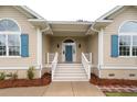 Inviting front entrance with a blue door, white railings, and well-maintained landscaping at 287 Commonwealth Rd, Mount Pleasant, SC 29466