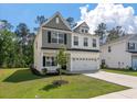 Charming two-story home with neutral siding, manicured lawn, and attached two car garage at 296 Torslanda Ln, Summerville, SC 29486