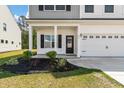 Inviting two-story home featuring a covered porch, well-maintained landscaping, and an attached two-car garage at 296 Torslanda Ln, Summerville, SC 29486