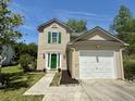 Charming two-story home featuring green shutters, a bright green door, a lush lawn, and a one-car garage at 319 Parish Park, Summerville, SC 29485