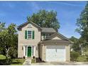 Charming two-story home featuring green shutters, a bright green door, a lush lawn, and a one-car garage at 319 Parish Park, Summerville, SC 29485