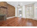 Spacious living room boasts hardwood floors, exposed brick wall, a fireplace and a chandelier at 35 Society St # D, Charleston, SC 29401