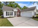Inviting one-story home featuring an attached garage, brick accents, and a concrete driveway at 4872 Law Blvd, Summerville, SC 29485