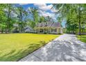 Inviting home with a lush green lawn, mature trees, and a long driveway at 5692 Barbary Coast Rd, Hollywood, SC 29449
