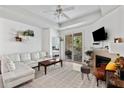 Bright living room features a white couch, fireplace, and access to the balcony at 60 Fenwick # 936, Johns Island, SC 29455