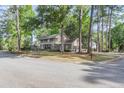Stunning brick house features a charming balcony and a two-car garage, surrounded by lush green trees at 615 Fairington Dr, Summerville, SC 29485