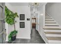 Inviting foyer with tile floors, a chandelier, staircase, and a decorative plant near the front door at 615 Fairington Dr, Summerville, SC 29485