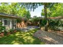 Brick patio with green grass, landscaping, and greenery creating a serene outdoor space at 620 Clearview Dr, Charleston, SC 29412