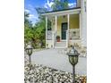 Inviting covered front porch with white railings, decorative anchor, and a well-lit walkway enhances the home's curb appeal at 675 Fair Spring Dr, Charleston, SC 29414