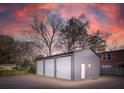 View of a three-car metal storage building with gravel parking and side Personal door at 706 White Oak Dr, Charleston, SC 29407