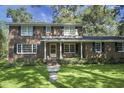 Traditional brick home with lush lawn, manicured landscaping, and welcoming front porch at 710 S Magnolia St, Summerville, SC 29483