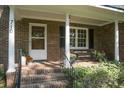 Charming brick home entrance with brick steps, quaint bench, and lovely plants at 710 S Magnolia St, Summerville, SC 29483