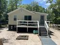 Charming home exterior with a deck, fire pit, and wooden walkway at 78 Hannibal Trl, Ridgeville, SC 29472