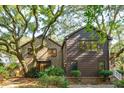 Unique home with brick and siding elements, complemented by mature trees and verdant landscaping at 810 Creekside Dr, Mount Pleasant, SC 29464