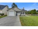 Charming single-story home featuring vinyl siding, an attached garage, well-kept lawn, and a cozy front porch at 8524 Brookforest Dr, Charleston, SC 29406