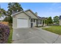 Single-story home features vinyl siding, attached garage, well-kept lawn, and a concrete driveway at 8524 Brookforest Dr, Charleston, SC 29406