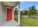 Inviting front porch with vibrant red door, hanging plants, and clear view of the house number at 8524 Brookforest Dr, Charleston, SC 29406