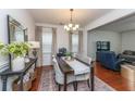 Elegant dining room featuring a stylish table set, hardwood floors, and natural light from the windows at 9767 Black Willow Ln, Ladson, SC 29456