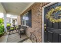 Inviting front porch with wicker seating and a decorative wreath on the front door, offering a cozy welcome at 9767 Black Willow Ln, Ladson, SC 29456