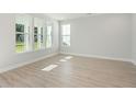Bright living room with large windows providing natural light and wood-look floors at 102 Hawthorne Landing Dr, Goose Creek, SC 29445