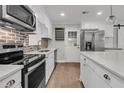Well-equipped kitchen with stainless steel appliances, white cabinets, and a brick backsplash at 105 Evatt Dr, Goose Creek, SC 29445
