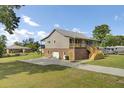 The side view highlights a brick foundation, a metal roof, a spacious driveway, and an expansive lawn, showcasing outdoor living at 108 Mourning Dove Dr, Bonneau, SC 29431