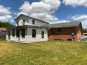 Backyard view showcasing a mix of brick and white siding, with a spacious lawn and trees around the property at 1110 Pickett St, Moncks Corner, SC 29461