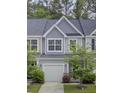 Charming townhouse features a one car garage, light gray siding and well-kept landscaping at 113 Alpine Rd, Summerville, SC 29485
