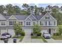 Street view of a row of townhouses, each with a garage, neutral color schemes, and young trees in the yards at 113 Alpine Rd, Summerville, SC 29485
