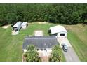 A beautiful single-Gathering home from above, showcasing a large detached garage, fenced yard, and mature trees at 131 Travis Hill Rd, Moncks Corner, SC 29461