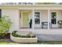 Inviting front porch featuring decorative plants, a stylish bench, and a cheerful yellow door at 1317 White Dr, Charleston, SC 29407