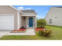 Inviting front entrance with a blue door, tasteful landscaping, and a well-maintained walkway at 151 Tyger St, Summerville, SC 29485