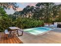 Enjoy the outdoors in this backyard featuring a refreshing in-ground pool, wooden picnic table and lush landscaping for privacy at 1511 Hopkins Ln, Mount Pleasant, SC 29466