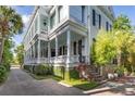 Stately home displaying a long veranda supported by grand columns, alongside lush greenery and hardscaped walkway at 155 Wentworth St # A, Charleston, SC 29401