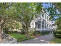 Elegant home showcasing a multi-story veranda, manicured lawn, and a paved driveway at 155 Wentworth St # A, Charleston, SC 29401