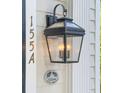 Close-up of front door with house number, gas lantern, and welcome pineapple symbol at 155 Wentworth St # A, Charleston, SC 29401