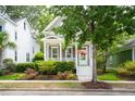Charming home exterior with a welcoming front porch, lush landscaping, and an American flag at 1629 Ware Bottom Ln, Mount Pleasant, SC 29464